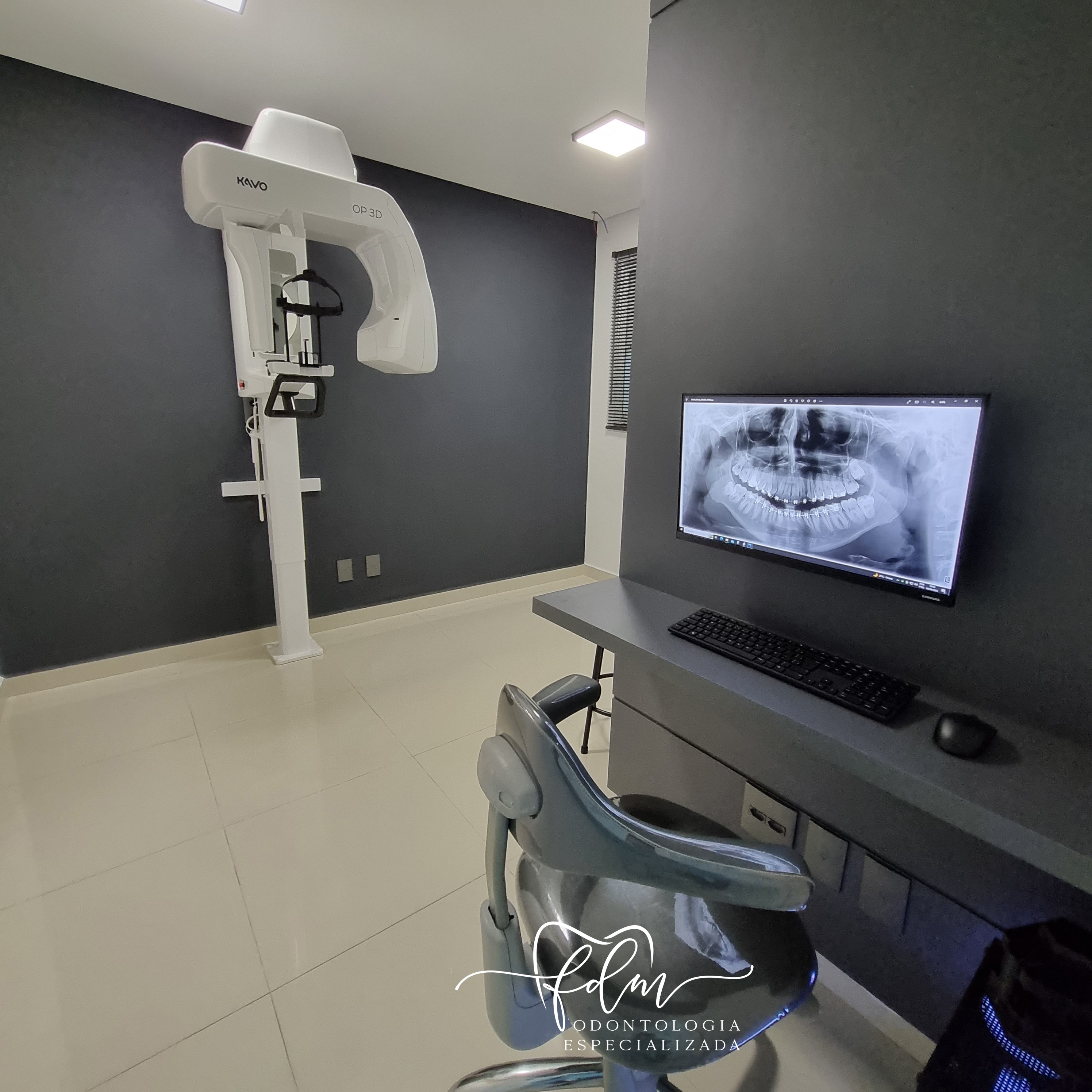 Sala com equipamento de radiografia panorâmica e monitor