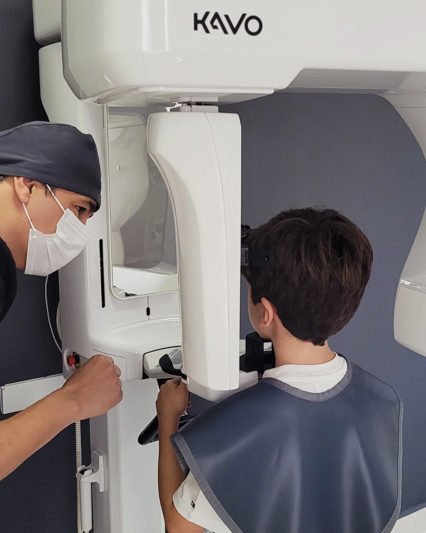 Profissional orientando paciente no equipamento de radiografia