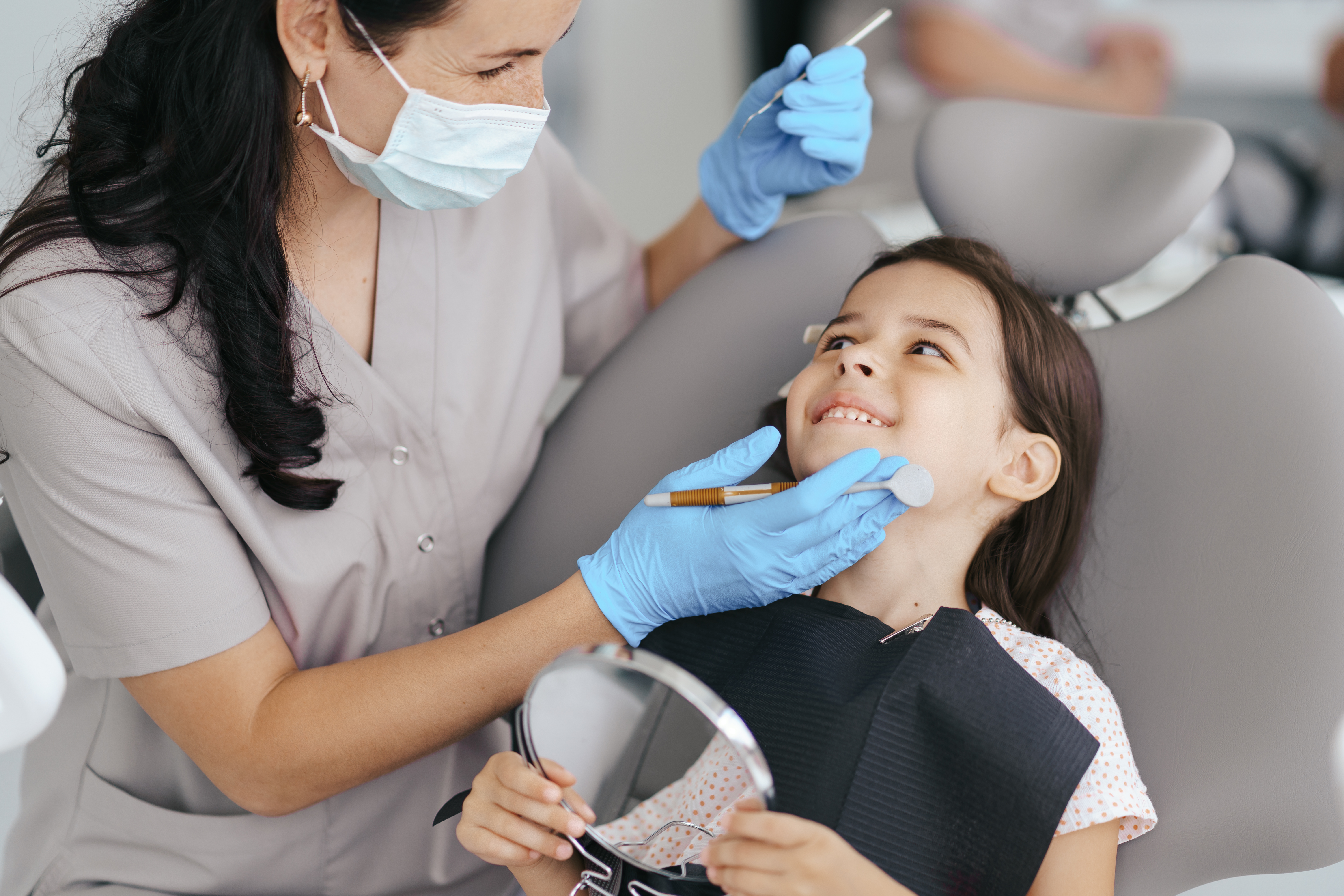 Criança sorrindo durante atendimento odontológico